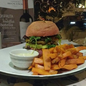 hamburguesa de lentejas en pan de remolacha con zanahorias saltedas