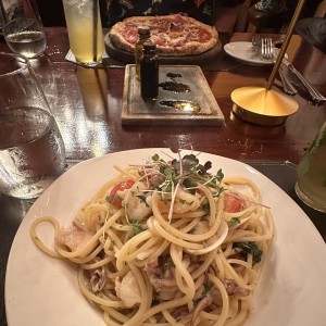 Spaghettoni en salsa de maricos y pizza de prosciutto y parmigiano.