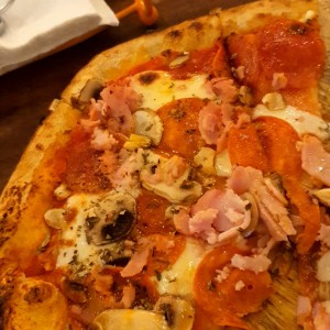 Pizza de pepperonni, jamón, hongos y queso mozzarella
