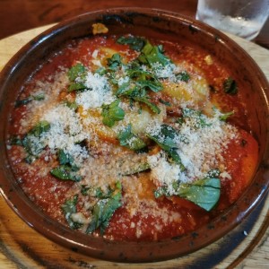 Raviolli rellena de queso en salsa pomodoro, albahaca y parmesano 