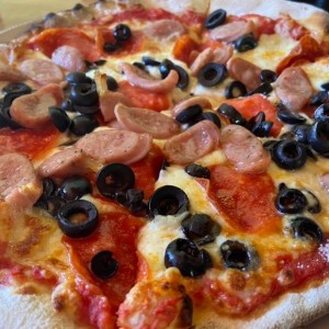 Pizza con pepperoni, salchicha italiana y aceitunas