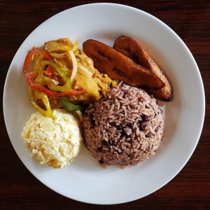 pollo guisado, ensalada de papas, tajadas y arroz con frijoles