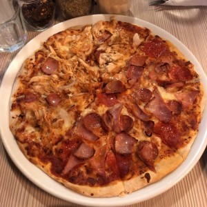 Deliciosa pizza mitad chicho?s y mitad chicken lovers.