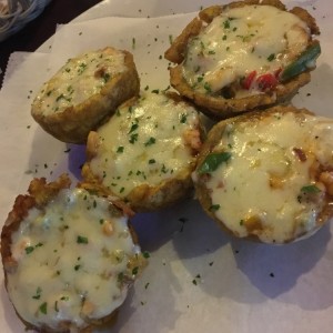 Patacones rellenos de mariscos gratinados con queso mozarella