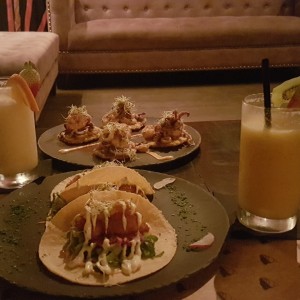 Tacos de pescado y patacones con mariscos