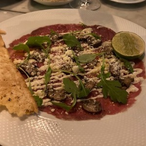 Carpaccio de Res, Creminis Asados, Parmesano D.O.P., y Mayonesa de Trufa Negra