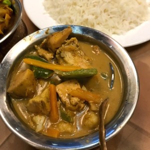 Thai Chicken Curry (tiene sabor a coco) y en el fondo arroz 