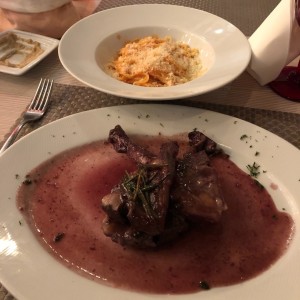 costillas de cordero con pasta en salsa rosada