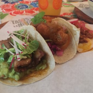 tacos de pescado, carne y chorizo con queso fundido