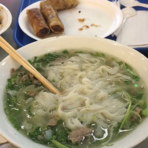 Pho de carne de res salteada y nem de carne.