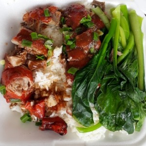 Pato asado con arroz blanco y hojas de mostaza