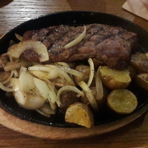 Sirloin steak con cebollas y papas