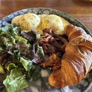 Huevos benedictinos con tocino y croissant