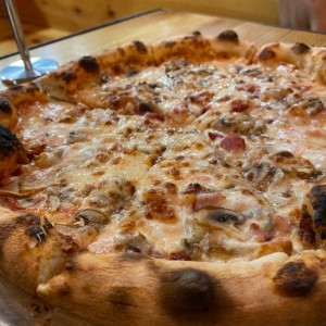 Pizza de mozzarella, bacon y hongos