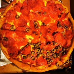 Pizza con doble pepperoni y aceitunas verdes. 