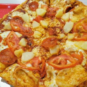 Pizza de peperoni, piña y tomate