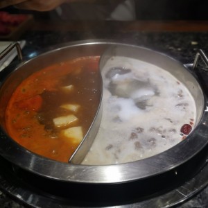 hot pot grande; caldo de tomate (derecha) y caldo de coco y ciruela (izquierda) 