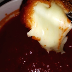 Cubos de queso en salsa de tomate.