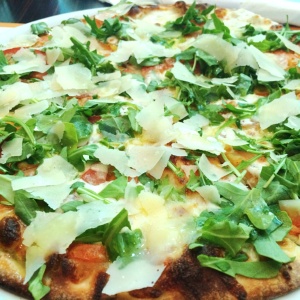 Pizza tomate fresco, mozzarella, arugula, parmesano en lascas y aceite de oliva