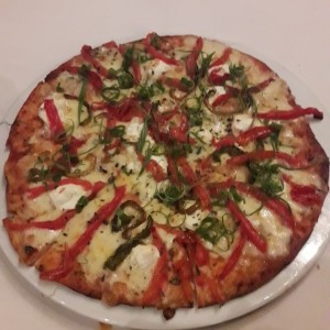 pizza con pimenton frito, queso de cabra, cebollin y tomates confitado