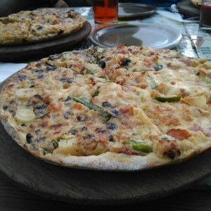Pizza a la crema, mitad vegetariana mitad tocineta  