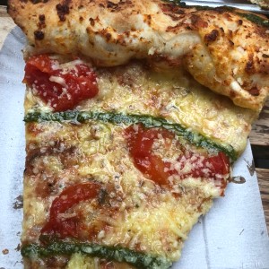 pizza con pesto y tomates.